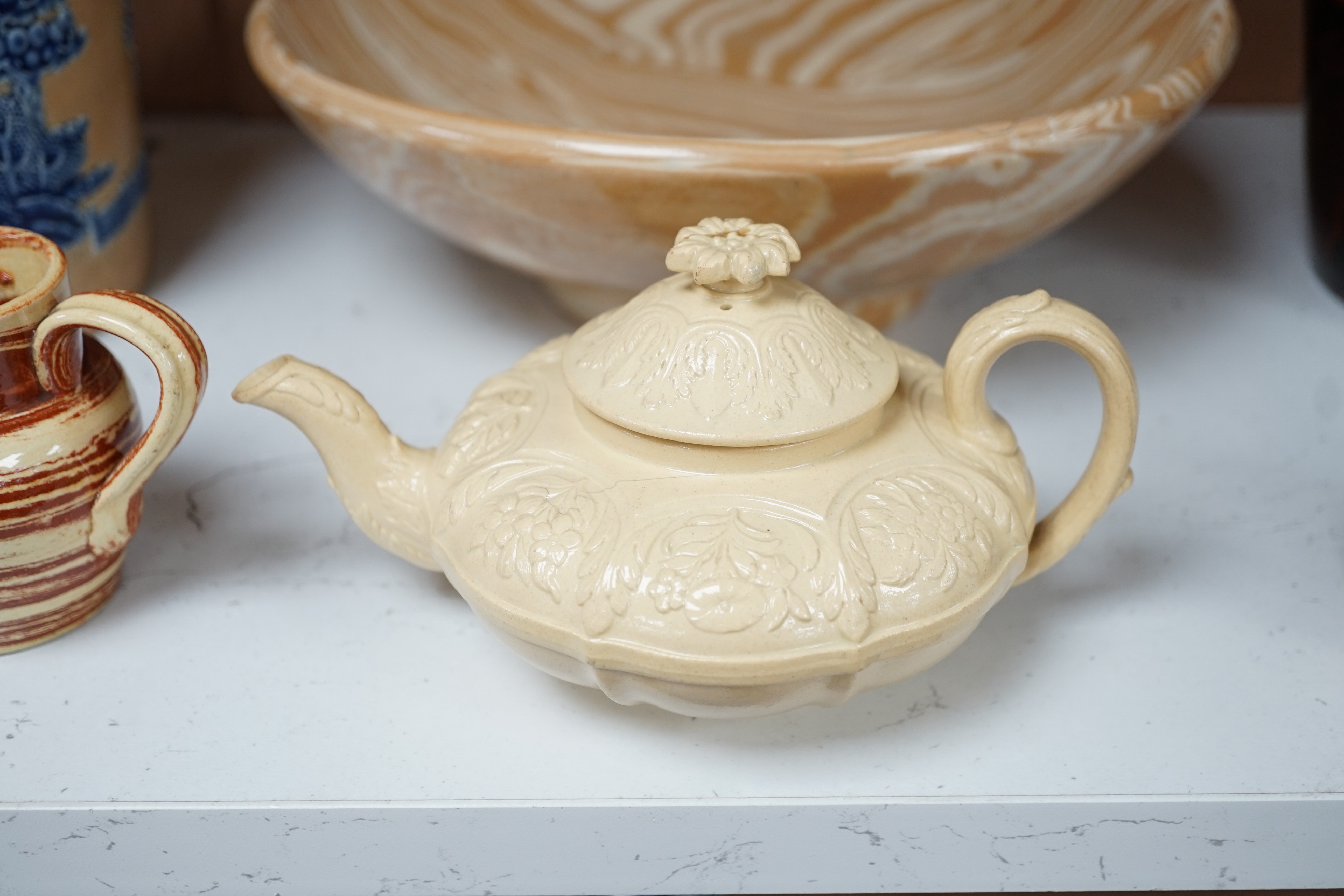A Victorian solid agate ware pottery jug, a similar bowl and pair of miniature jugs, an unusual Doulton Lambeth stoneware jug and a small relief-moulded teapot, Doulton jug, 19cms high